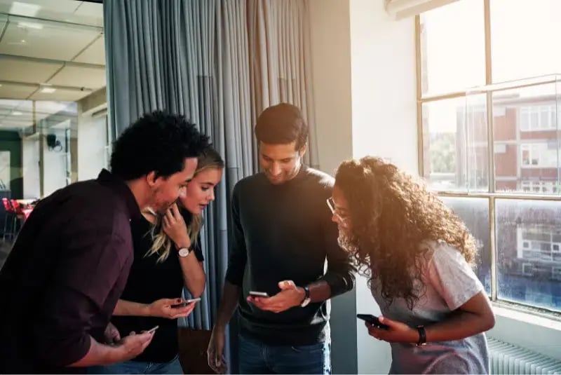 Een groep mensen die naar een mobiel kijken