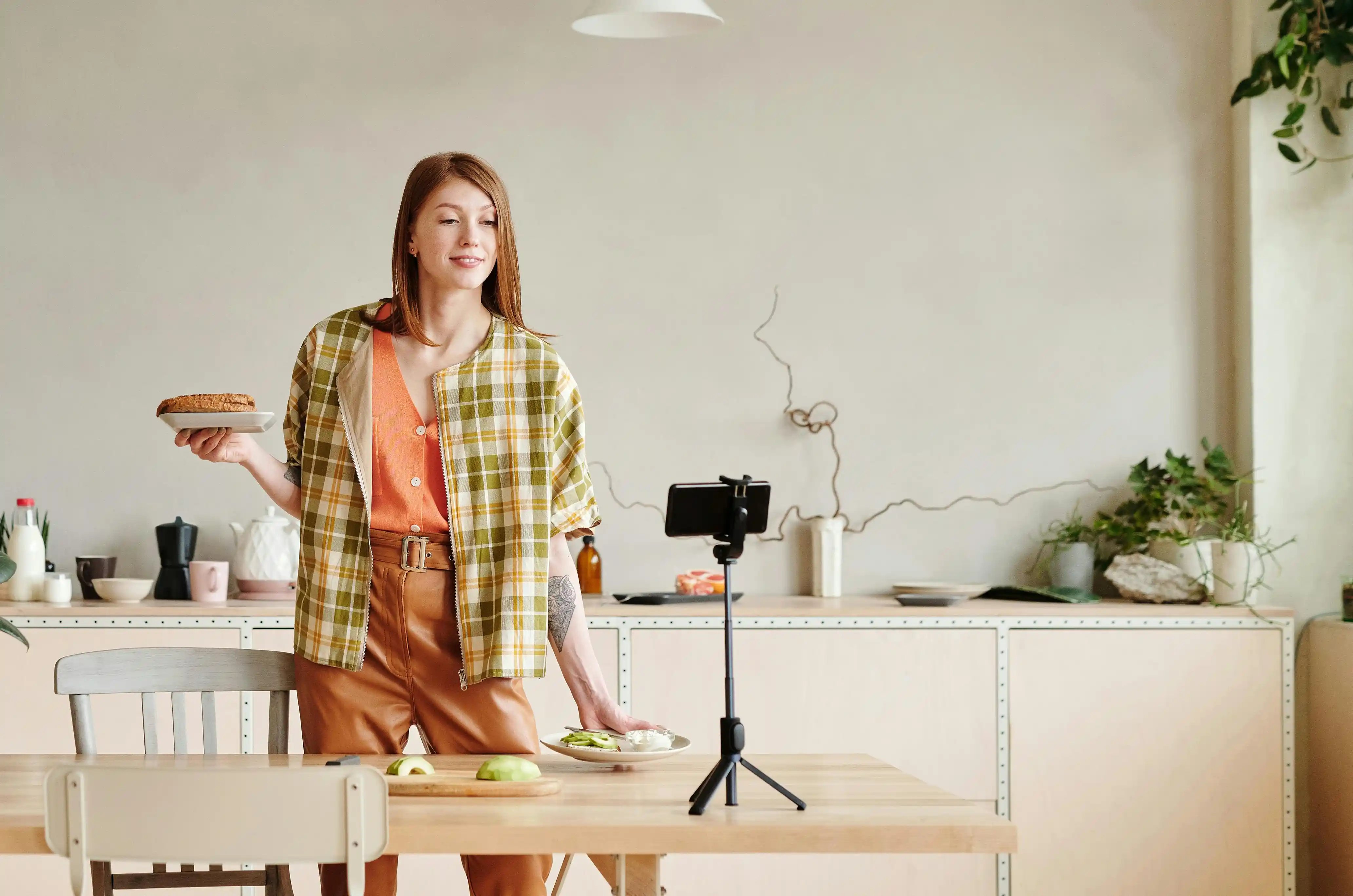 Influencer die met eten in haar handen voor een camera staat