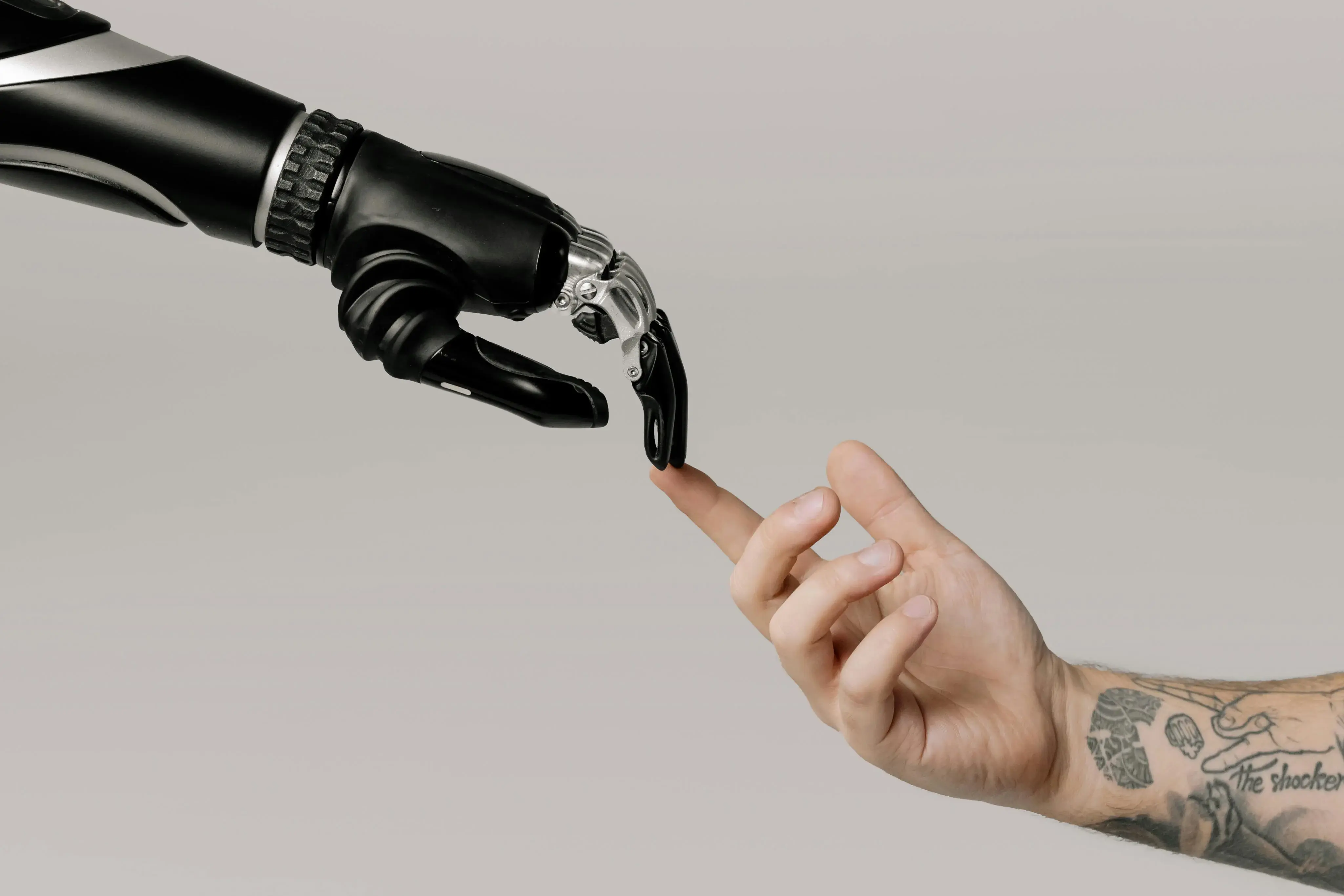 Foto van een mensen- en robothand die naar elkaar uitreiken