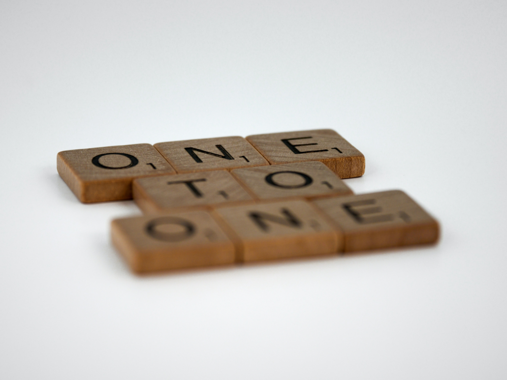 Scrabble stenen die de woorden one on one tonen